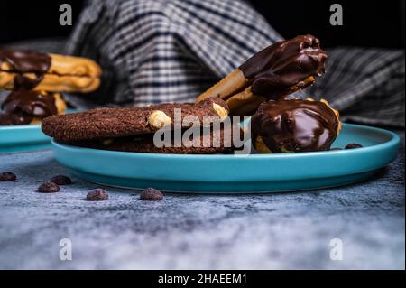 Biscotti digestivi ricoperti di cioccolato fondente con biscotti al cioccolato per i vostri cari festeggiamenti di giorno. Parzialmente mangiato con briciole. Vista laterale. Foto Stock