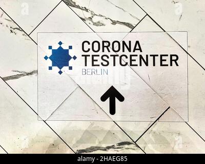 Cartello sul pavimento di un centro commerciale di Berlino che indica la strada per un centro di test Corona. Foto Stock