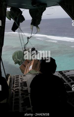 Moch Island, Stati Uniti. 06 dicembre 2021. U.S. Airman Heidi Hymel, 734th Air Mobility Squadron, guarda un pacchetto che ha spinto da un aereo C-130J Super Hercules caduta sulla riva durante l'operazione annuale 70th Natale goccia 6 dicembre 2021 su Moch Island, Micronesia. Ogni dicembre, gli equipaggi airdrop hanno donato cibo, forniture, materiale didattico e strumenti a 55 nazioni insulari in tutto il Pacifico sudorientale. Credito: TSgt. Joshua Edwards/US Airforce Photo/Alamy Live News Foto Stock