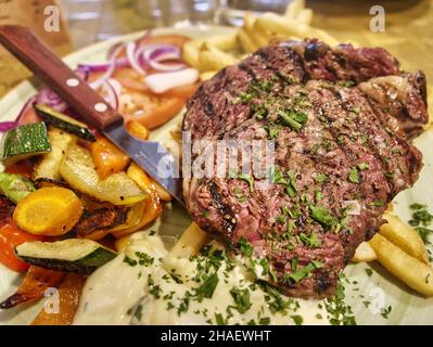 piatto di bistecca alla griglia con rosmarino, verdure e patate Foto Stock