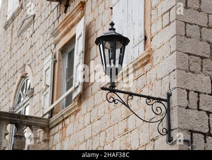 Vecchio forgedlantern vintage su muro di pietra di un vecchio edificio Foto Stock