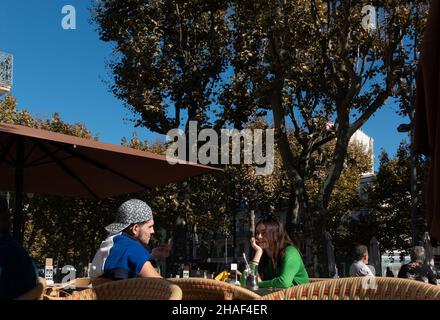Una giovane coppia che siede fuori in un caffè di strada francese Foto Stock