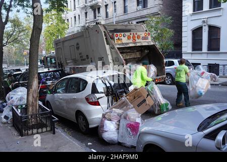 New York, NY - 18 novembre 2021: Le auto parcheggiate che bloccano il marciapiede rendono la rimozione dei rifiuti più impegnativa a Manhattan Foto Stock