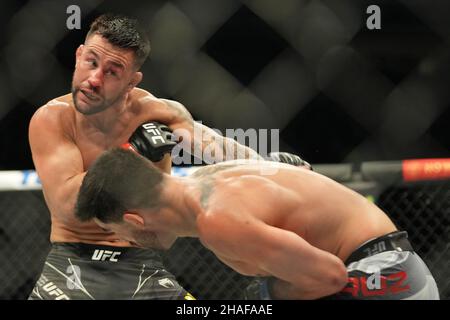 LAS VEGAS, NV - 11 DICEMBRE: (L-R) Pedro Munhoz batte Dominick Cruz nella loro lotta di peso corporeo durante la UFC 269: Oliveira / Poirier evento alla T-Mobile Arena il 11 dicembre 2021 a Las Vegas, Nevada, Stati Uniti. (Foto di Louis Grasse/PxImages) Credit: PX Images/Alamy Live News Foto Stock