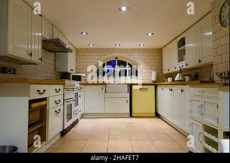 Cucina seminterrata in stile retrò con elettrodomestici moderni e illuminazione a soffitto Foto Stock