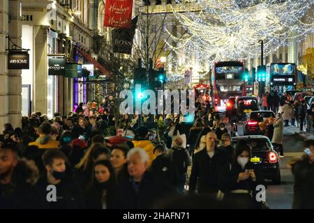 Londra, Regno Unito, 12th dicembre 2021. Gli acquirenti e coloro che amano le luci di Natale nel West End riempiono Regent Street mentre il governo del Regno Unito eleva il livello di allerta del Covid a quattro, nel mezzo di un raddoppio dei casi di variante Omicron. Il primo ministro Boris Johnson farà annunci su un discorso televisivo alla nazione questa sera. Credit: Undicesima ora Fotografia/Alamy Live News Foto Stock