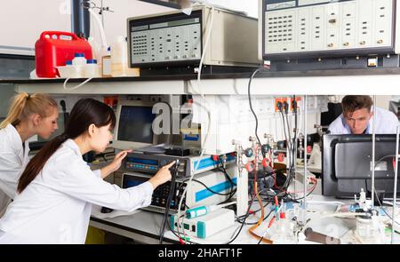 Vista del moderno laboratorio di ricerca universitario con gruppo multirazziale di studenti che effettuano esperimenti su attrezzature da laboratorio Foto Stock