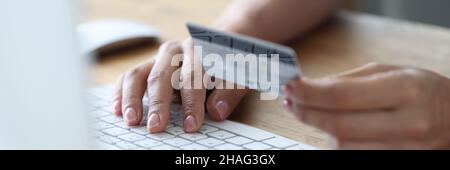 Donna che paga online con carta di credito di plastica primo piano Foto Stock