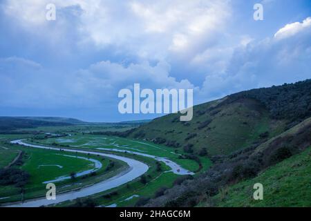 Nuvoloso dicembre sorgere del sole da alto e sopra guardando verso il basso la valle di Cuckmere e il fiume fino alla costa, Sussex est sud-est Inghilterra Foto Stock