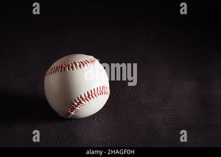 Palla da baseball su sfondo marrone scuro con spazio copia. Foto Stock