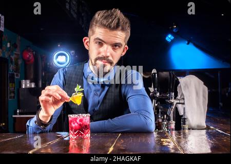 Il barman mescola un cocktail nella casa Foto Stock