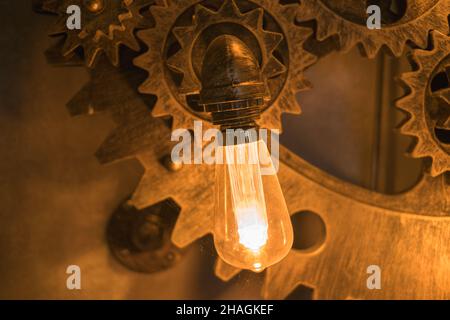 Steampunk stile architettonico elemento di design di interior.lampade lampadine fissate su ferro ingranaggi industriali ruote dentate illuminazione apparecchiature illuminate Foto Stock