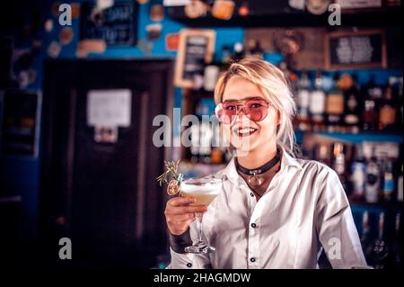 Il barman ragazza mescola un cocktail sulla casa della beerhouse Foto Stock