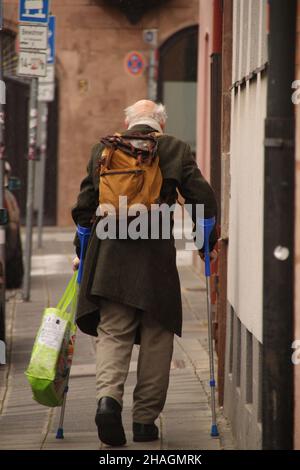 Vista posteriore di un uomo anziano con bastoni da passeggio in strada Foto Stock