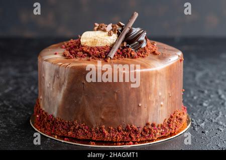 Banana e torta al cioccolato su sfondo scuro. Vista orizzontale. Primo piano torta di festa Foto Stock