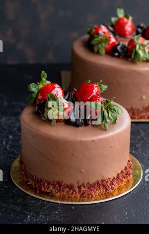 Torta di fragole e cioccolato su sfondo scuro. Vista verticale. Primo piano torta di festa. Formato storia Foto Stock