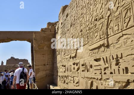 Persone in un'escursione al Tempio di Karnak. Turisti tra le antiche rovine. Famoso punto di riferimento egiziano con geroglifici e templi decaduto. Luxor, Egy Foto Stock