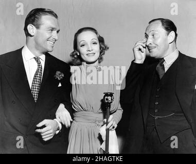 DOUGLAS FAIRBANKS Jr. MARLENE DIETRICH e LIONEL ATWILL al microfono di Los Angeles durante un adattamento di radiodiffusione per il Lux radio Theatre / Teatro di CANZONE DI CANZONI il 20th 1937 dicembre al Music Box Theatre di Hollywood ospitato da Cecil B. DeMille Pubblicità per Columbia Broadcasting Sistema (CBS) Foto Stock