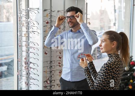 Maschio testare nuovi occhiali mentre si guarda a distanza Foto Stock