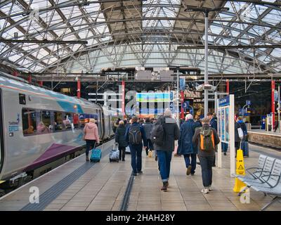 I passeggeri camminano lungo il binario della stazione dopo aver lasciato il treno TransPennine Express da Newcastle alla stazione di Lime Street a Liverpool, Regno Unito Foto Stock