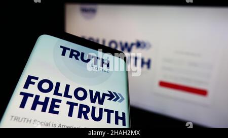 Telefono cellulare con pagina web della piattaforma media americana VERITÀ sociale (da TMTG) sullo schermo di fronte al logo. Mettere a fuoco sulla parte superiore sinistra del display del telefono. Foto Stock