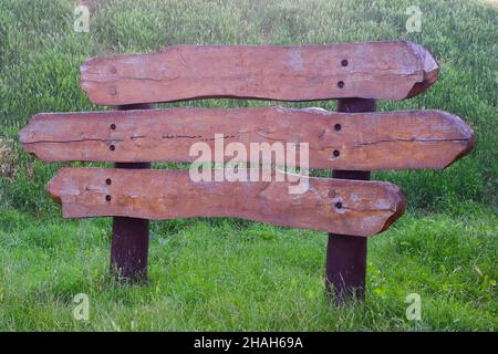 Grande cartello decorativo di tre assi orizzontali con spazio vuoto per iscrizioni su ciascuno di essi su sfondo di erba verde Foto Stock