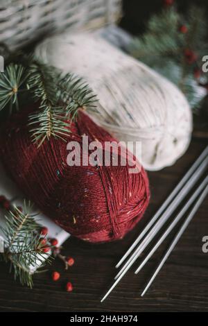 Matasse di filo di lana con aghi su sfondo scuro. Concetto per vita lenta fatta a mano e hygge. Foto Stock