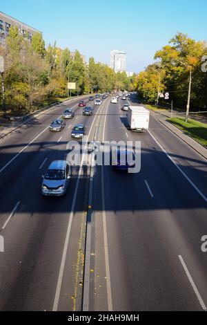 Molte auto sono fotografate dall'alto da un'angolazione elevata. Le auto viaggiano in direzioni diverse su una strada larga Foto Stock