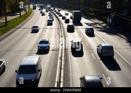 Molte auto sono fotografate dall'alto da un'angolazione elevata. Le auto viaggiano in direzioni diverse su una strada larga Foto Stock