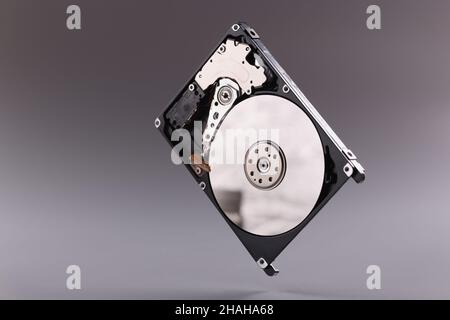 Disco rigido HDD con coperchio superiore aperto su sfondo grigio Foto Stock