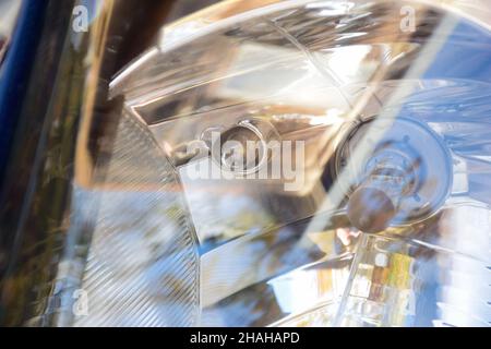 Faro di un'auto moderna da vicino con le lampadine viste attraverso il vetro Foto Stock