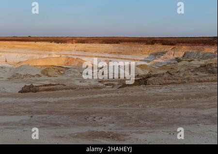 Cava di sabbia. Laguna turchese e miniera di superficie con minerali colorati esposti, attrezzatura in fondo alla fossa. Foto Stock