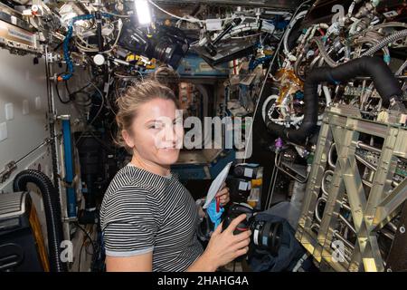 ISS - 04 Dicembre 2021 - astronauta della NASA e spedizione 66 tecnico di volo Kayla Barron è raffigurato ispezionando e fotografando componenti all'interno del Foto Stock