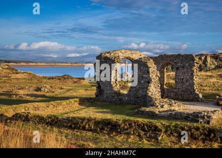La croce celtica e le rovine della chiesa di San Dwynwen sull'isola di Llanddwyn, Isola di Anglesey, Galles del Nord Foto Stock