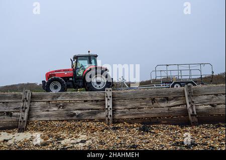 Solent Rescue Red massey ferguson, trattore e rimorchio per imbarcazioni di soccorso parcheggiato su una sponda di ciottoli a Lepe Beach, recinzione in legno resistente alle intemperie. Lepe Country Park Foto Stock