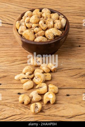 Canjica, popcorn hominy o bianco, popcorn dolce in una ciotola sopra tavola di legno. Foto Stock