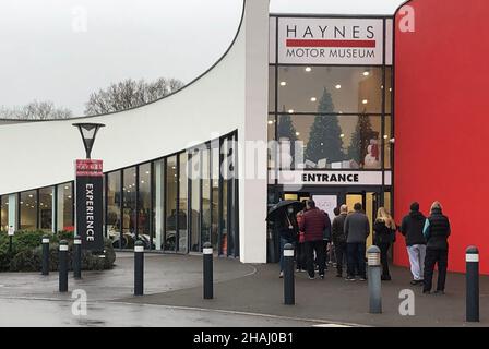 Le persone che si accingono per i booster jab presso il centro di vaccinazione Covid-19 presso l'Haynes Motor Museum, vicino a Yeovil, Somerset. A tutti gli oltre 18 in Inghilterra saranno offerti booster jab da questa settimana, il PM ha detto Domenica notte, come ha dichiarato una 'emergenza Omicron'. Data foto: Lunedì 13 dicembre 2021. Foto Stock