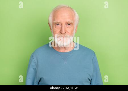 Foto di uomo di barba sambuco stretto indossare maglione blu isolato su sfondo di colore verde Foto Stock