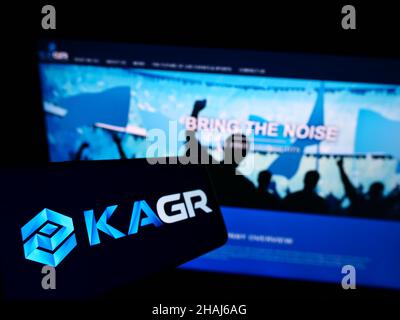 Telefono cellulare con logo della società statunitense KAGR LLC (Kraft Analytics Group) sullo schermo di fronte al sito web aziendale. Mettere a fuoco sulla sinistra del display del telefono. Foto Stock