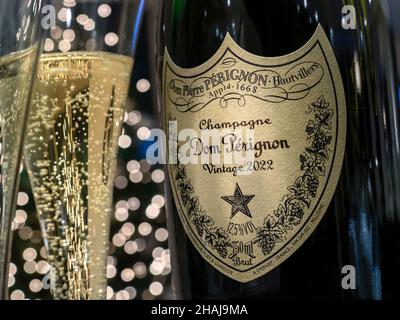 Dom Perignon 2022 bottiglia di champagne etichetta e bicchiere con bolle, festa con luci scintillanti sullo sfondo Capodanno festa in hotel Foto Stock