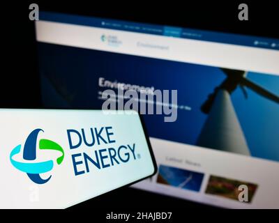 Smartphone con logo della società statunitense Duke Energy Corporation di energia e gas sullo schermo di fronte al sito Web. Messa a fuoco al centro-sinistra del display del telefono. Foto Stock