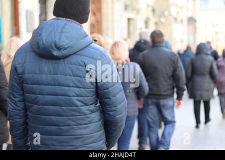 Folla anonima di persone che camminano sulla strada della città. Turisti che viaggiano in Europa. Vista posteriore Foto Stock