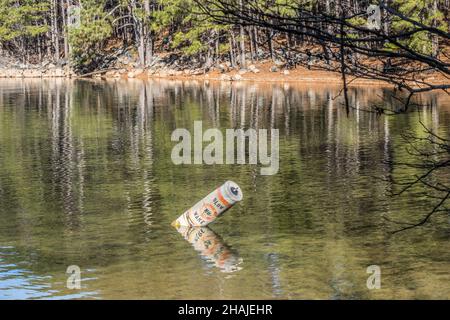 Rotto e incrinato nessun boa di wake galleggiante sul suo lato un avvertimento di andare lento in acque poco profonde nell'insenatura del lago con la costa nel backgrou Foto Stock