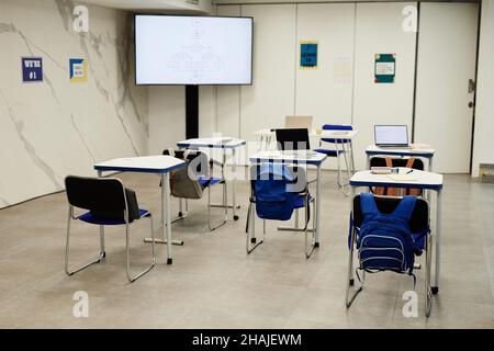 Immagine di sfondo della programmazione in aula nella scuola moderna con codice sullo schermo, spazio di copia Foto Stock