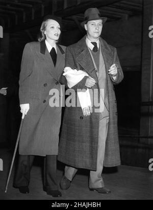 MARLENE DIETRICH (usando la canna a causa di un danno alla caviglia) e suo marito RUDOLF SIEBER camminando attraverso la Grand Central Station di New York nel 1941 Foto Stock