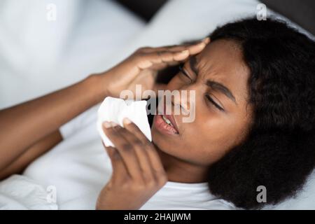 Primo piano di malata donna nera che si stenderà a letto Foto Stock