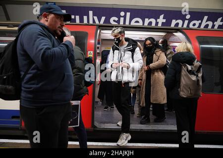 Pendolari sulla piattaforma della Central Line in direzione est alla stazione della metropolitana di Oxford Circus alle 17:42 nell'ora di punta della sera, dove sono state introdotte nuove restrizioni per rallentare la diffusione della variante Omicron del coronavirus. Data foto: Lunedì 13 dicembre 2021. Foto Stock