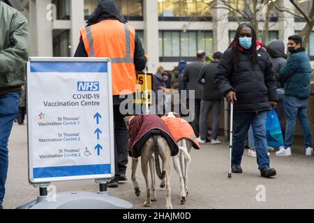 Londra UK 13 dicembre 2021. Le persone si sono unite a una coda di sei ore per ricevere la vaccinazione covid-19 come programma di booster del governo britannico e della NHS turbocharge contro l'onda di marea di Omicron. A tutti gli adulti in Inghilterra viene offerto un jab booster entro la fine dell'anno in mezzo al livello di allerta Covid è stato innalzato dal livello 3 al livello 4 la scorsa domenica. Credit: Xiu Bao/Alamy Live News Foto Stock