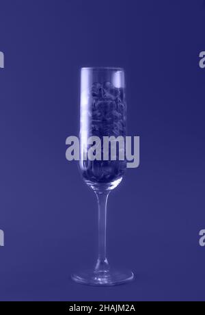 Bella carta con bicchiere di champagne riempito di cuori trasparenti tonici di colore alla moda dell'anno 2022. Concetto di amore e celebrazione. Design eccellente per qualsiasi scopo. Primo piano. Foto Stock