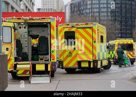 Londra UK 13 dicembre 2021. Ambulanze di Londra in standby all'esterno dell'ospedale NHS. Le persone si sono unite a una lunga coda per ricevere la vaccinazione covid-19 come programma di booster del governo britannico e dell'NHS turbocharge contro l'onda di marea di Omicron. A tutti gli adulti in Inghilterra viene offerto un jab booster entro la fine dell'anno in mezzo al livello di allerta Covid è stato innalzato dal livello 3 al livello 4 la scorsa domenica. Credit: Xiu Bao/Alamy Live News Foto Stock